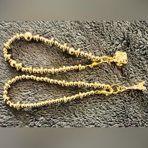 Two gold pendent bracelets.